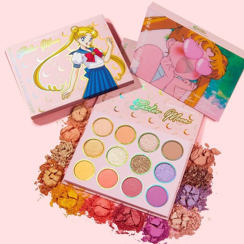 A pink eyeshadow palette open with the the box cover featuring Sailor Moon on it