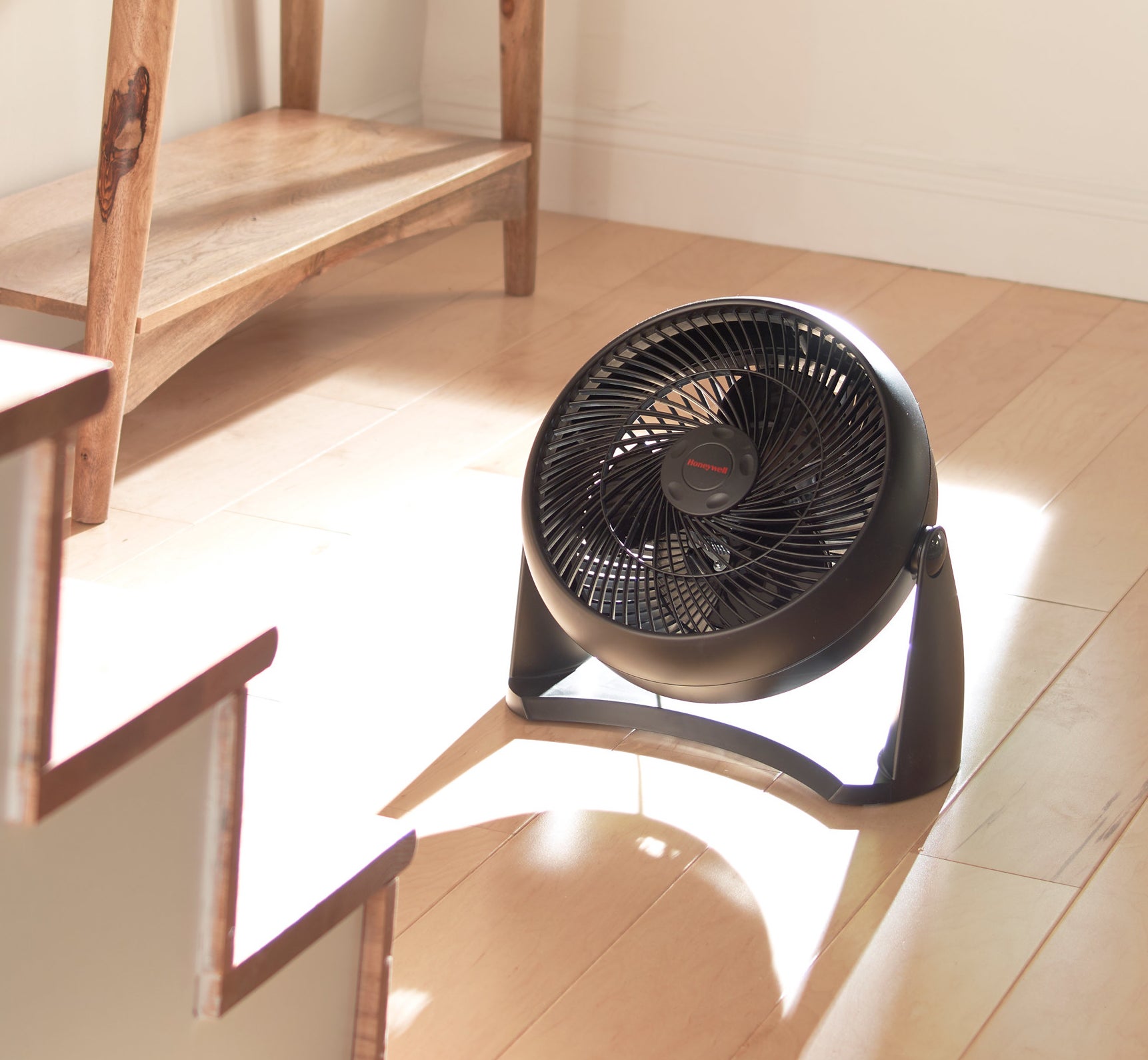 a black fan sitting on the ground of a foyer