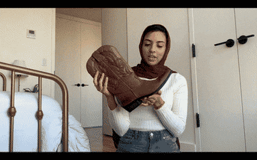 A gif of someone holding and showing the details of the boots