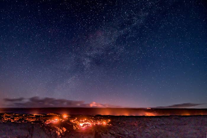 Lava lighting up the sky on a starry night