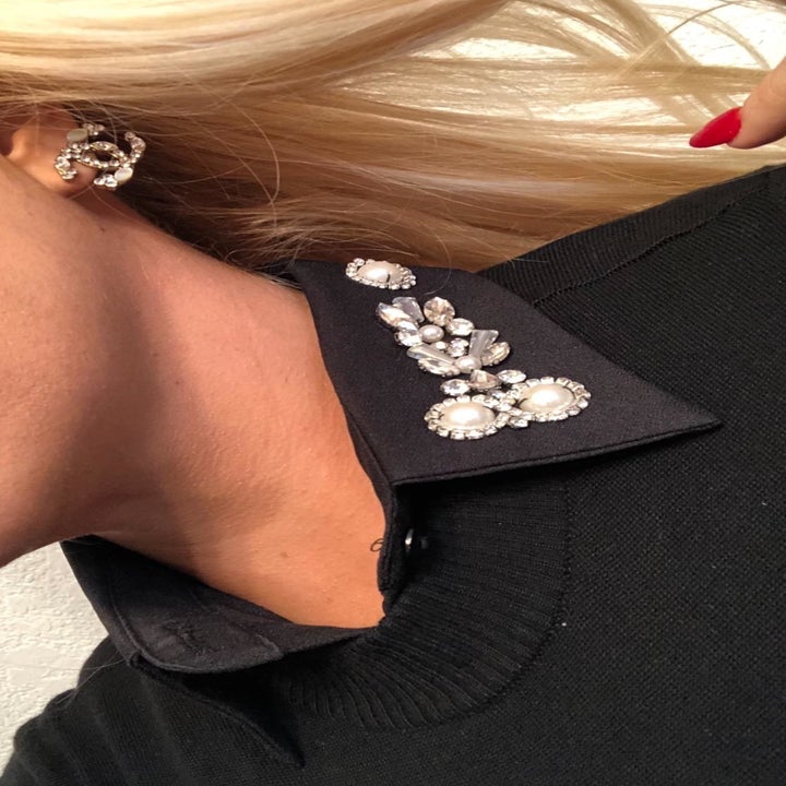 A reviewer wearing the black collar under a sweater