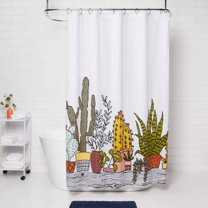 The curtain half closed in front of the tub