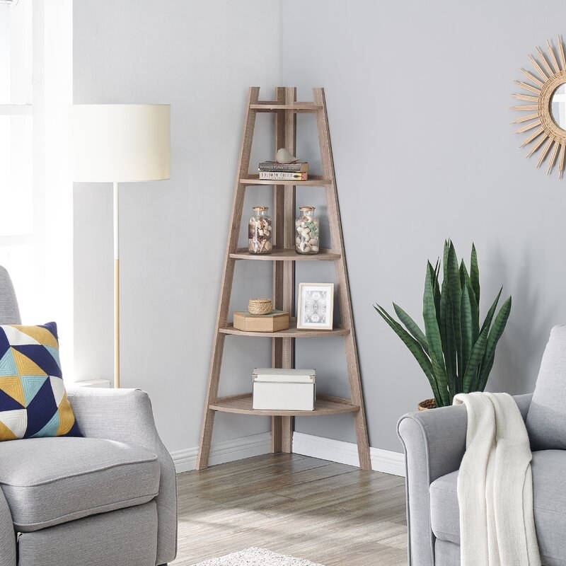 A tripod bookshelf with 5 triangular shelves that get smaller farther up the shelf, designed to fit in a corner
