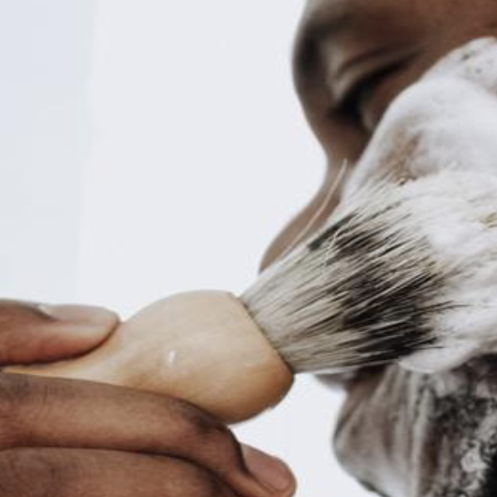 A close-up of a man lathering up his face with the shaving soap