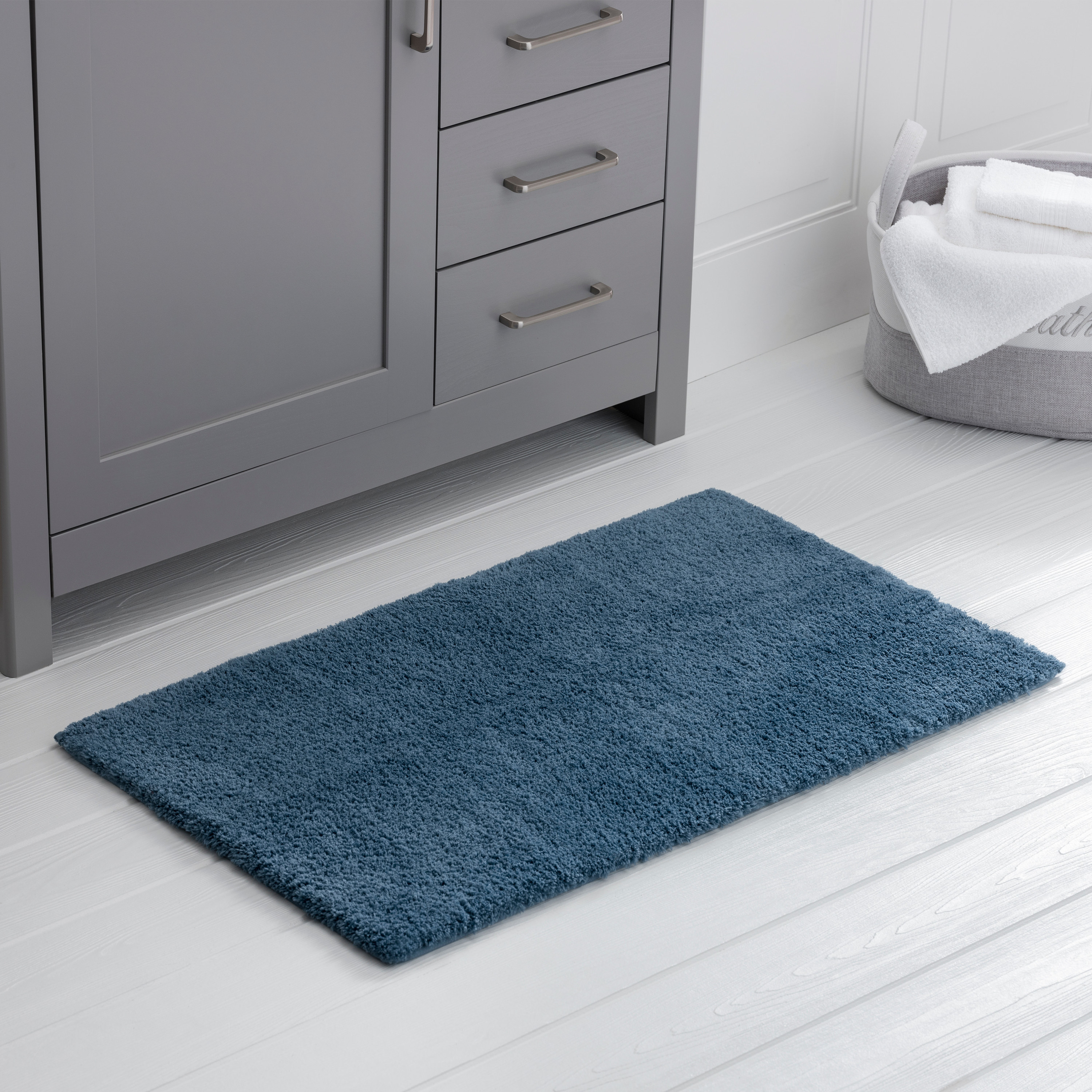 a dark blue plush rug in a bathroom 