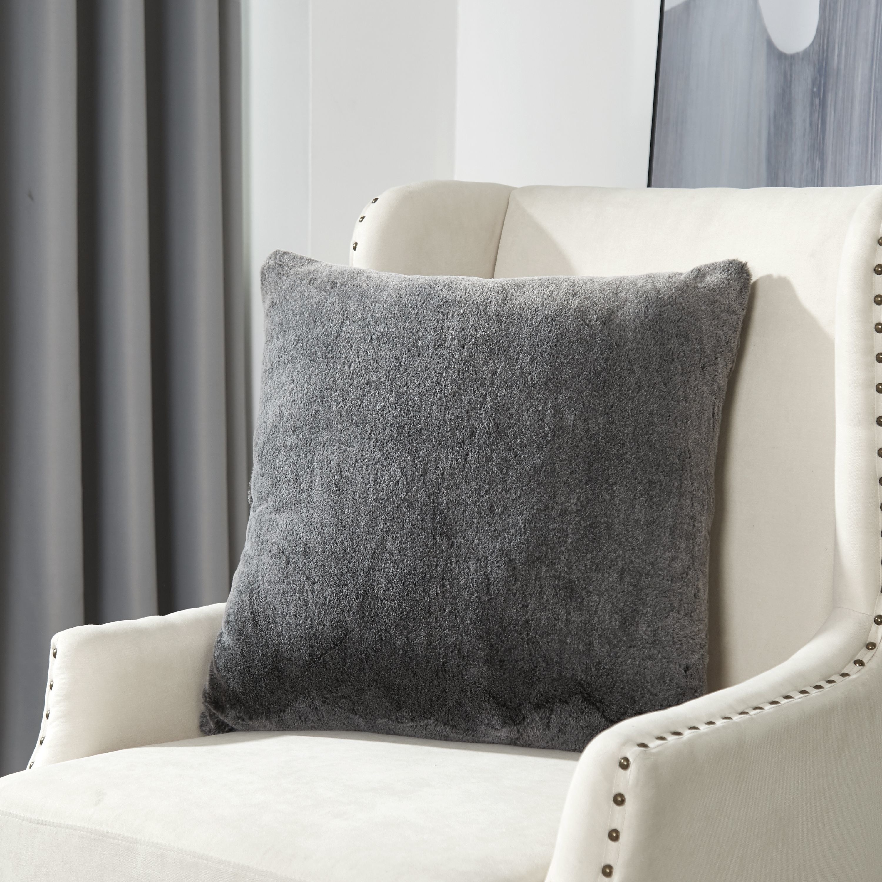 gray faux fur pillow on a white chair