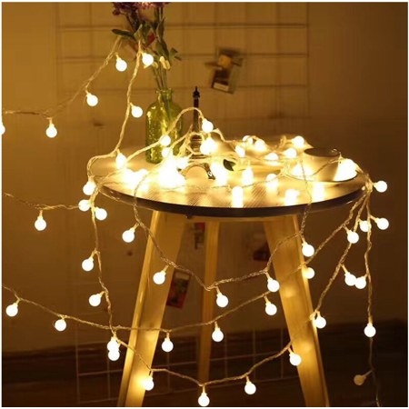 the small lit bulbs on the string lights gathered on a table 