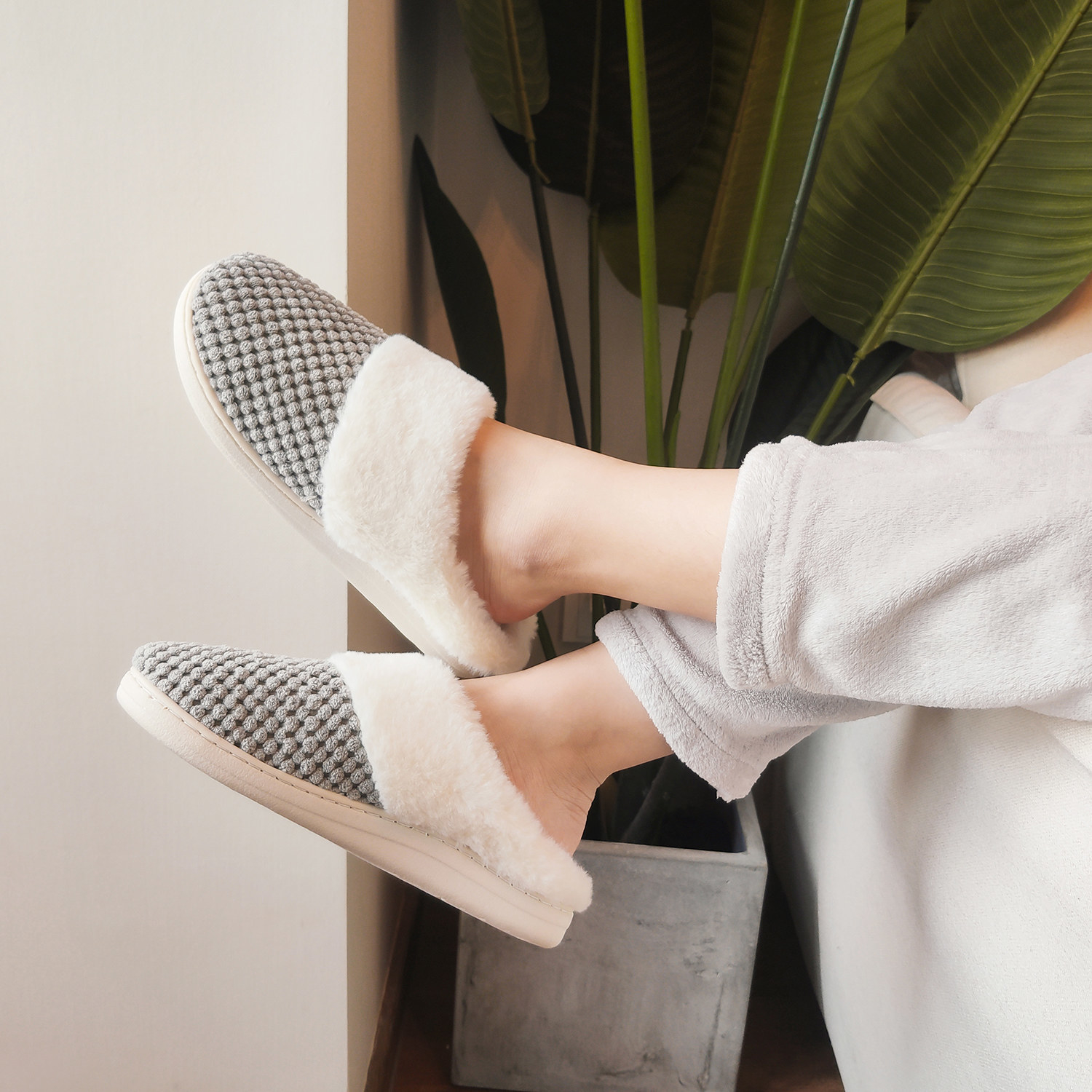 gray slip-on slippers with fleece lining on a pair of feet