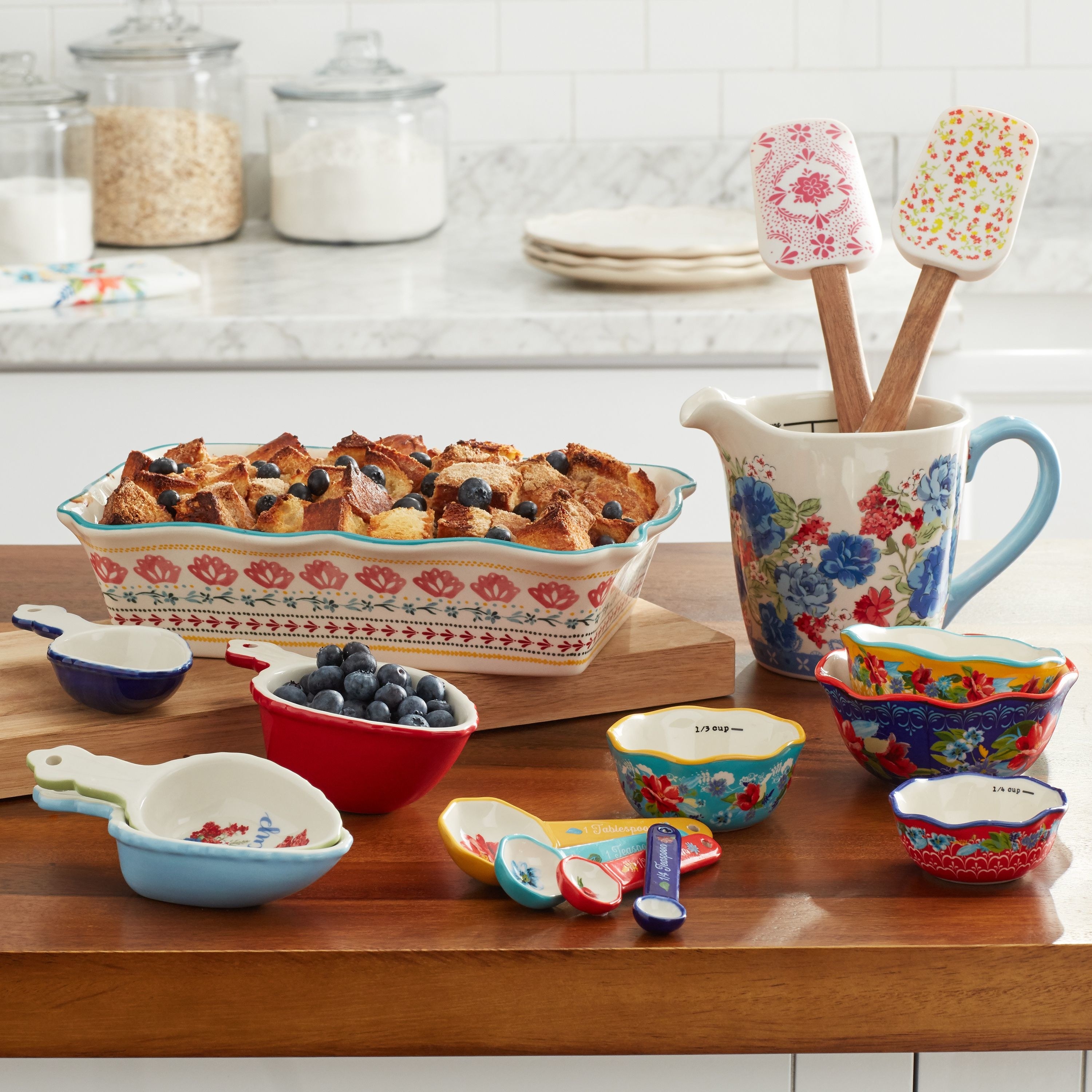 ceramic floral baking set including measuring spoons, cups, spoonulas, and a baking pan.