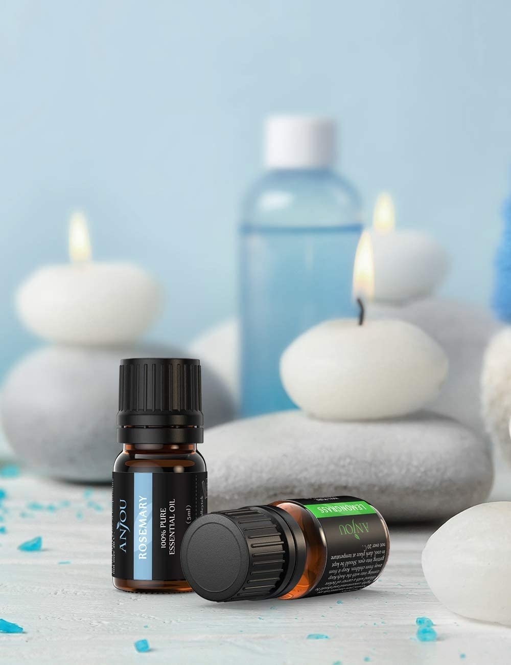 two bottles of essential oils surrounded by pebble candles