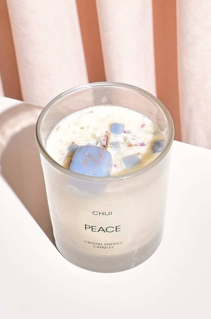 a matte glass candle with blue crystal stones in the top of it