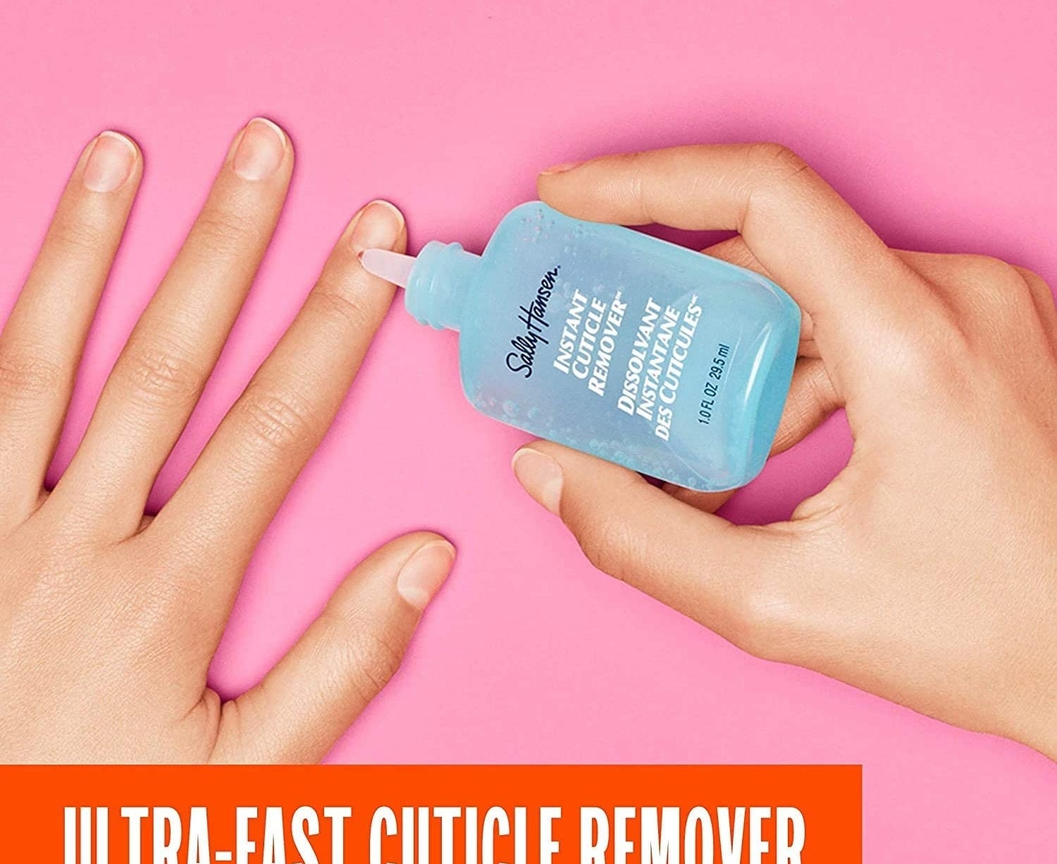 A person holding the cuticle removing solution to their cuticle
