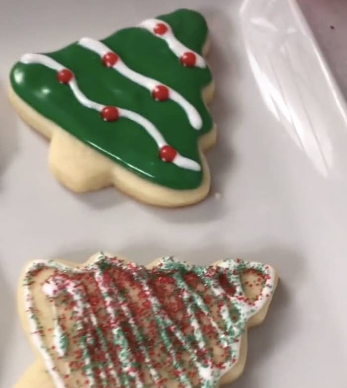 A sugar cookie shaped like a Christmas tree with green frosting