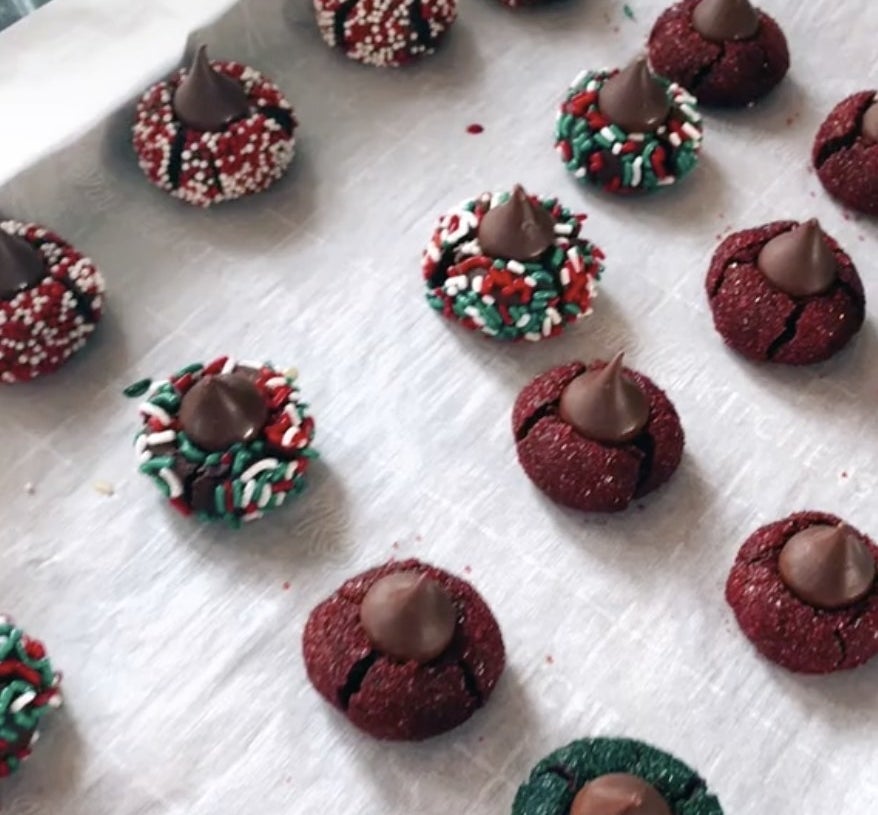 Chocolate cookies covered in red and green sprinkles and a Hershey&#x27;s kiss on top