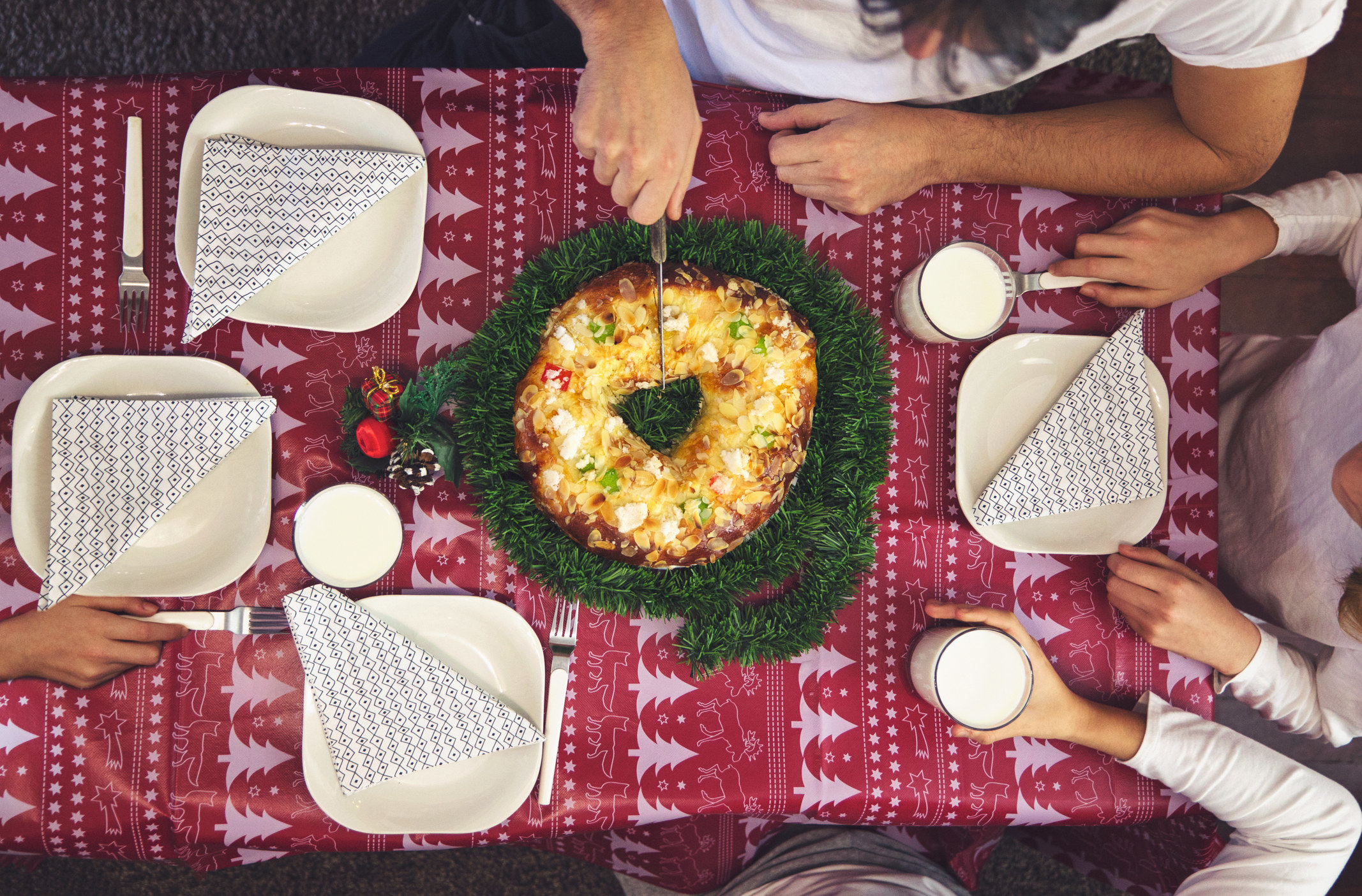 Over headshot of a family cutting into a Rosca