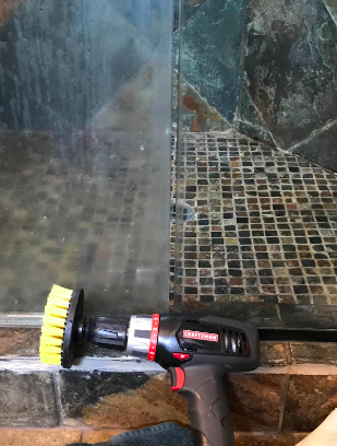 Reviewer&#x27;s glass shower doors. One opaque with hard water stains and the other completely clear after being cleaned with the drill brushes 