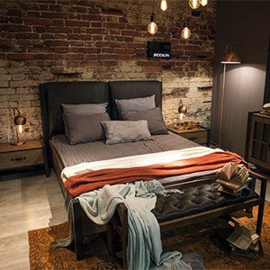A bedroom with the lightbulbs in bedside lamps