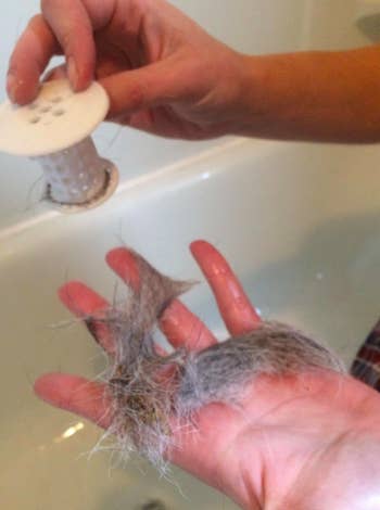 Reviewer holding Tub Shroom after pulling out handful of short hairs 