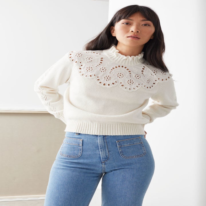 white sweater with lace embellishment and mid-high collar 