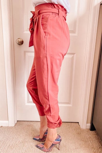 Side view of a reviewer wearing the pants in salmon pink