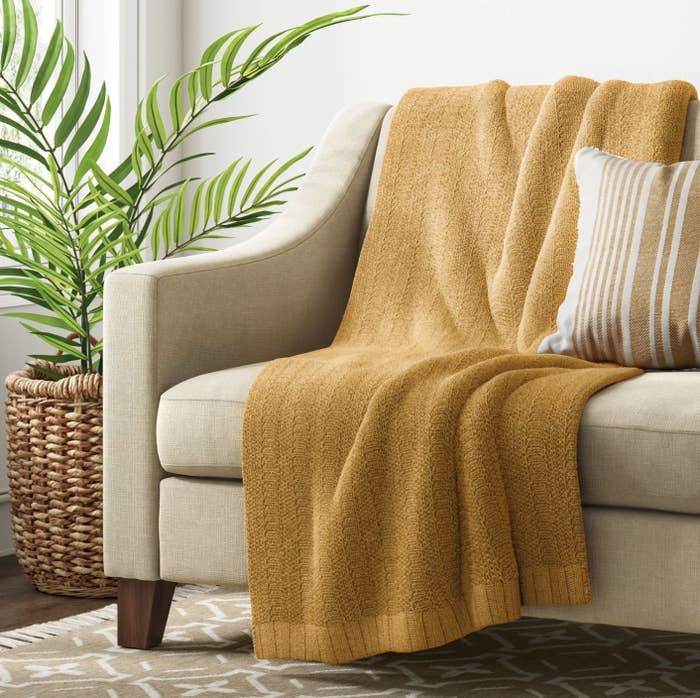 The mustard yellow throw blanket on a couch