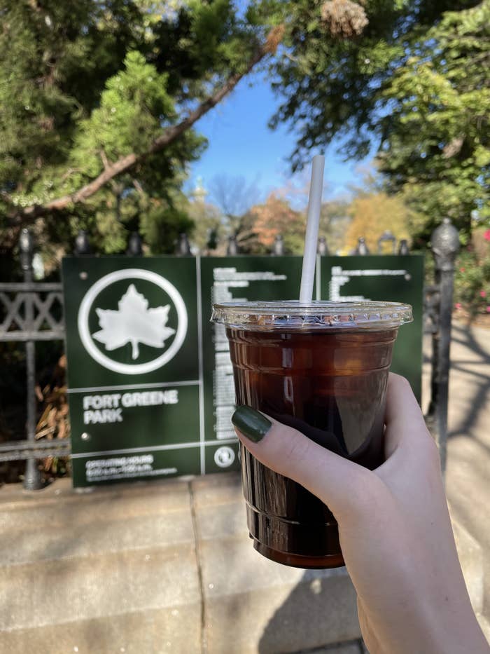 Dariya holding an iced coffee while in a public park