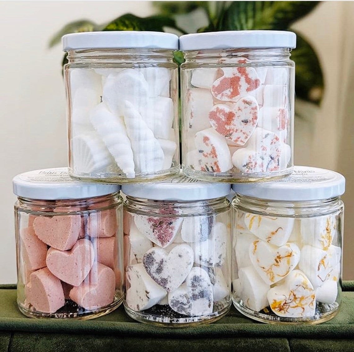 Five glass jars filled with heart-shaped bath bombs