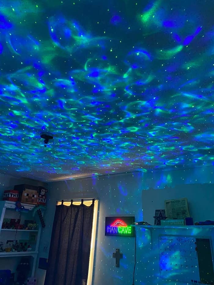 reviewer image of a bedroom whose walls and ceiling are covered in LED ocean wave lights