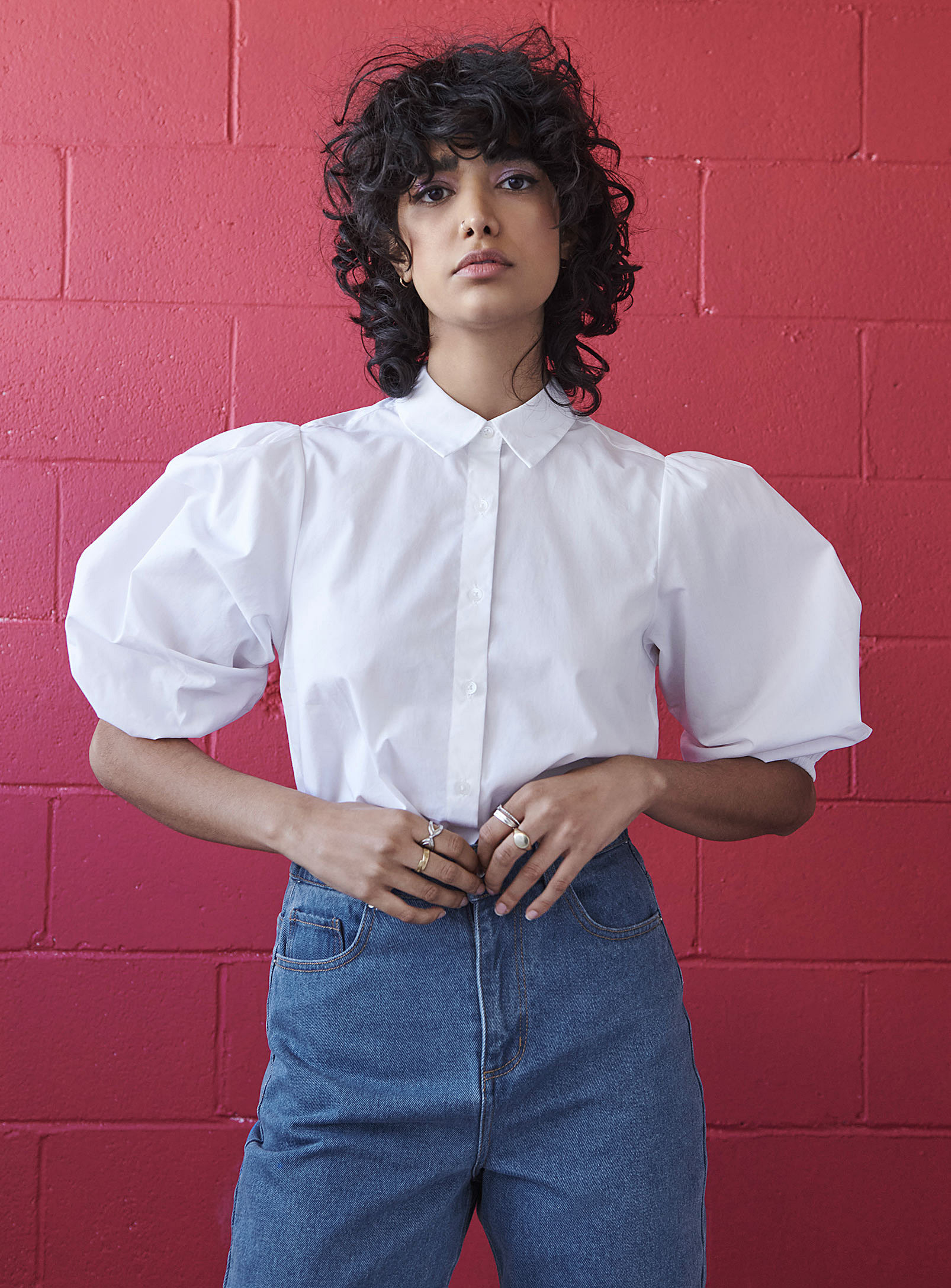 A person wearing a button up shirt with exaggerated puffy sleeves