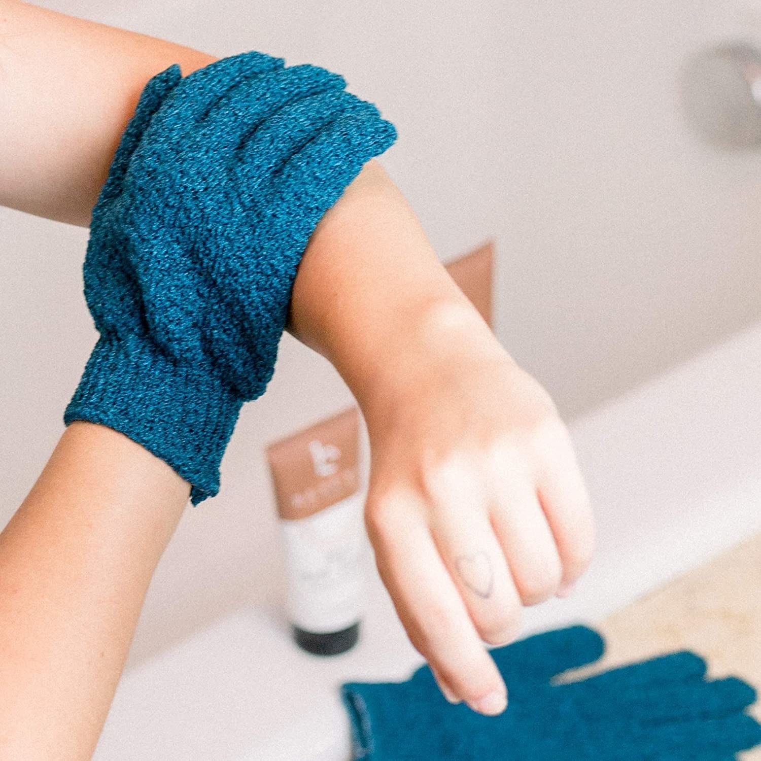 A person scrubbing their arm with a glove