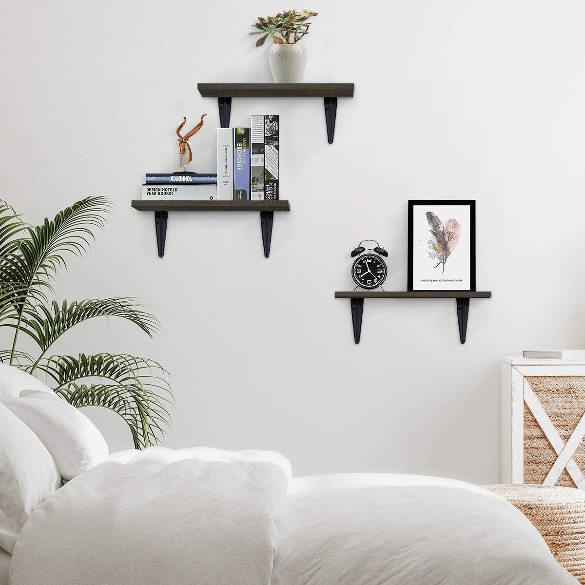 Three floating shelves with various items on them, like books, a clock, and artwork