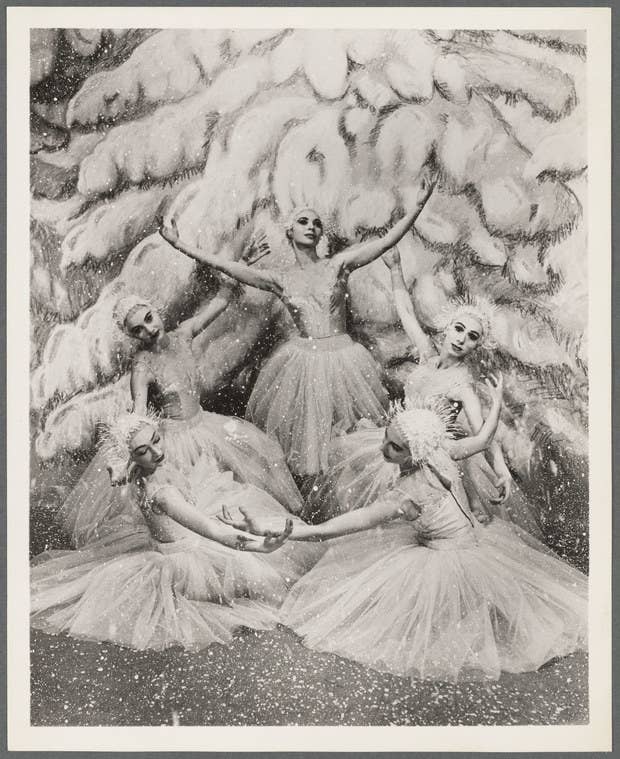 Women in ice costumes in front of a painted Christmas tree
