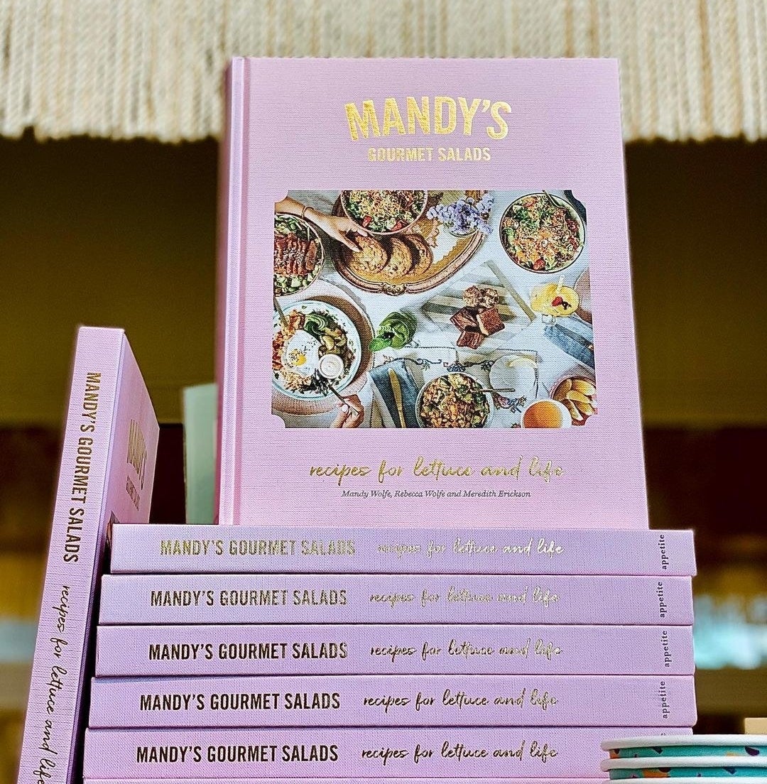 A stack of cookbooks with one balanced on the top