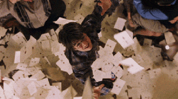 Harry grabbing at letters that are falling to the ground while a pile of letters is already on the ground