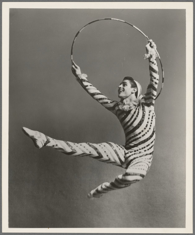 Man in a striped candy cane costume jumping with a hula hoop