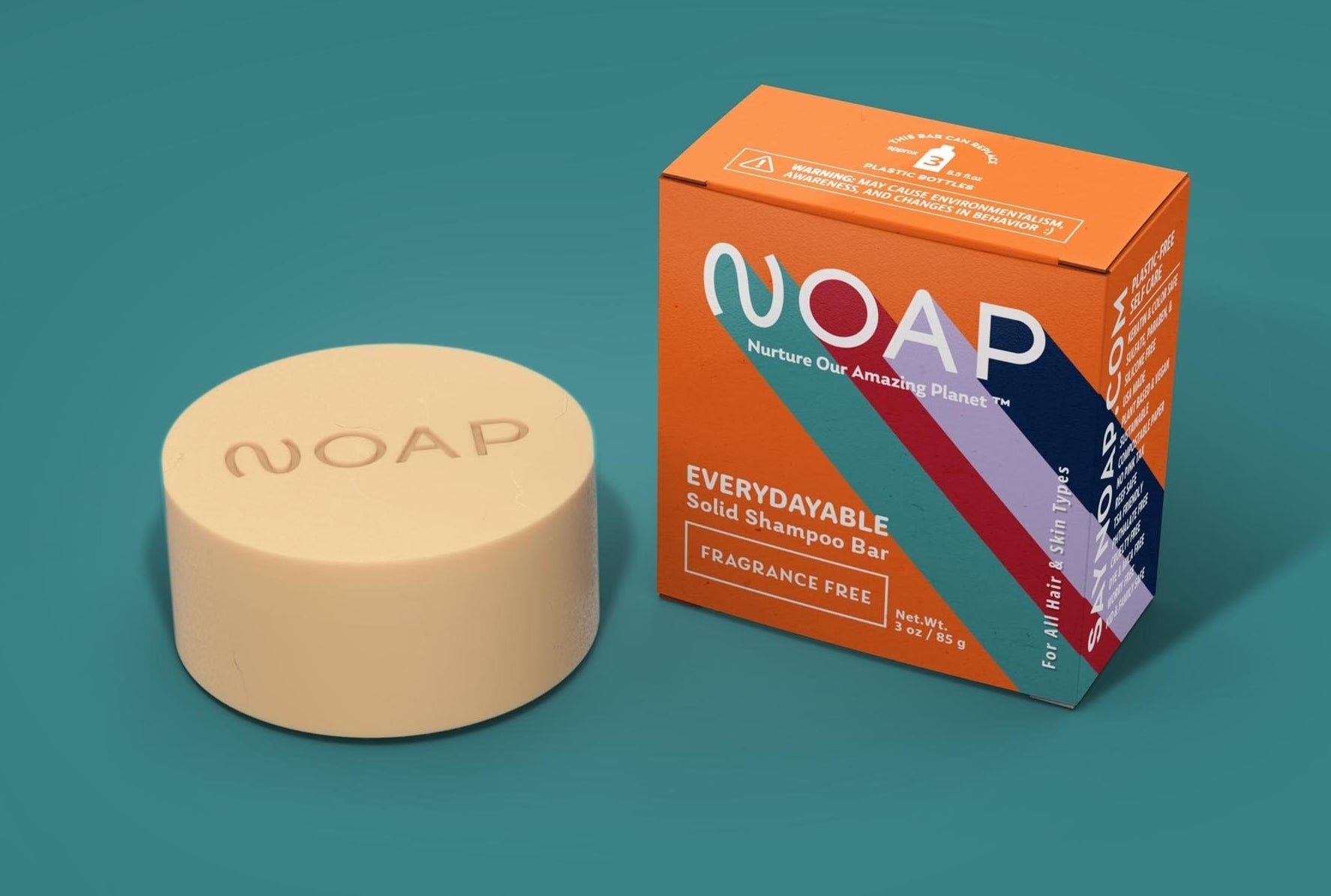 An orange box that says "NOAP Everydayable Solid Shampoo Bar, Fragrance Free" sitting next to a cream-colored round bar