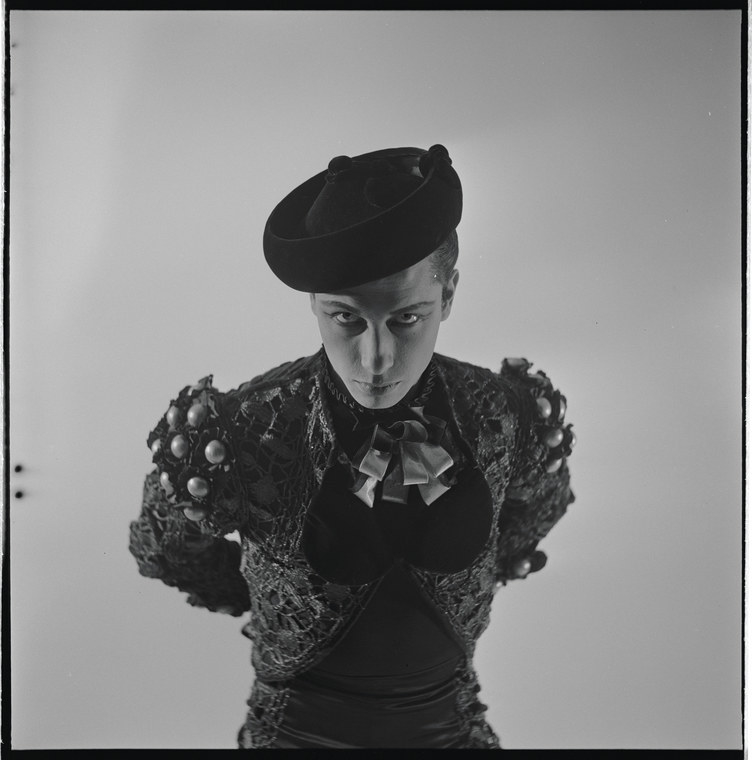 Man in a matador outfit leering at camera on a blank background