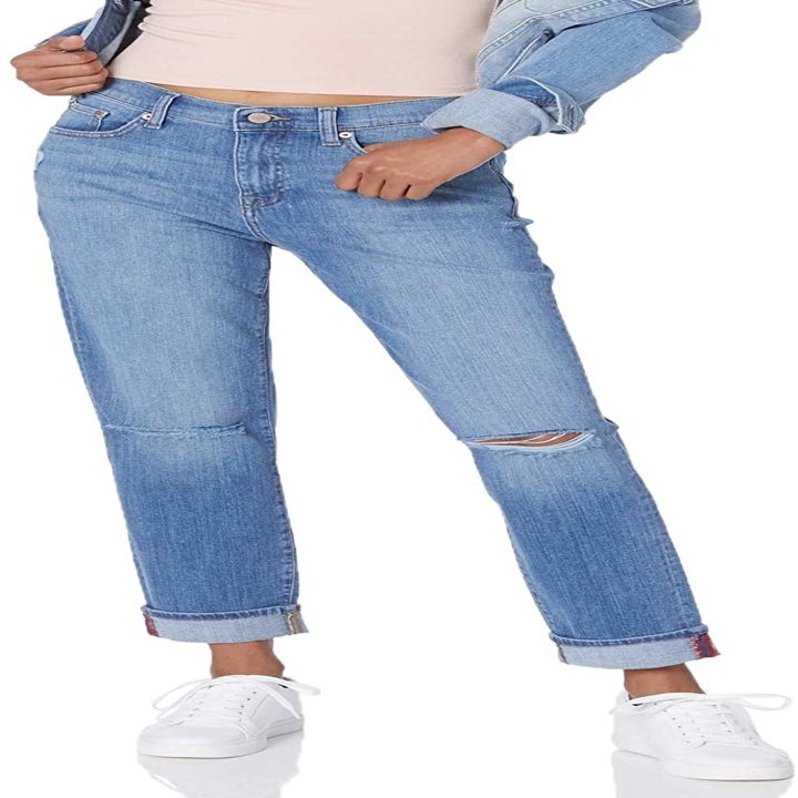A model wearing the light wash cuffed jeans with rips at the knees