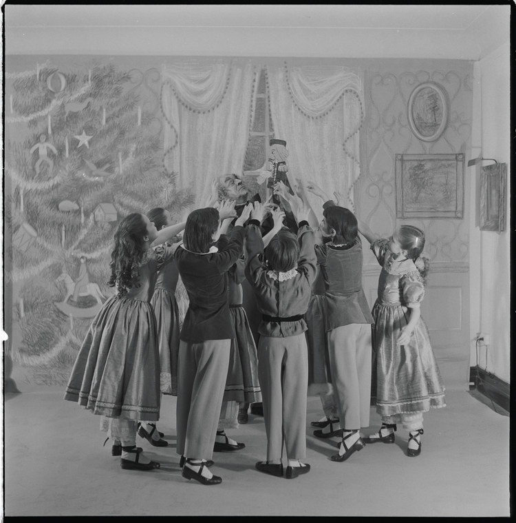 Children surrounding the old man and the nutcracker on a dance set 