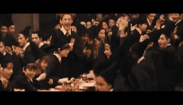 The Gryffindors throw their hats into the air and cheer