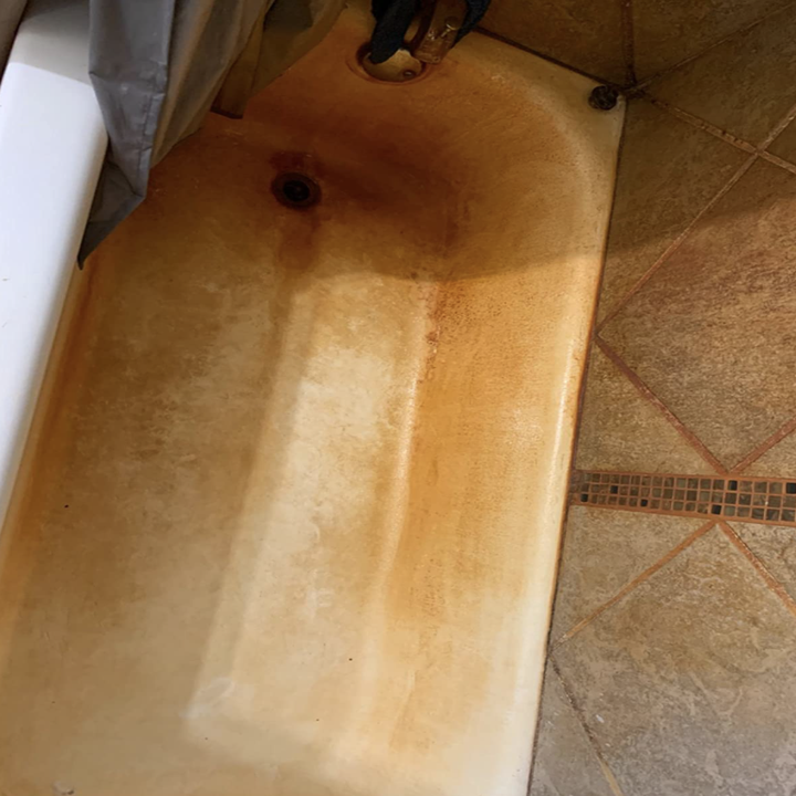 reviewer's before photo of tub completely covered in rust
