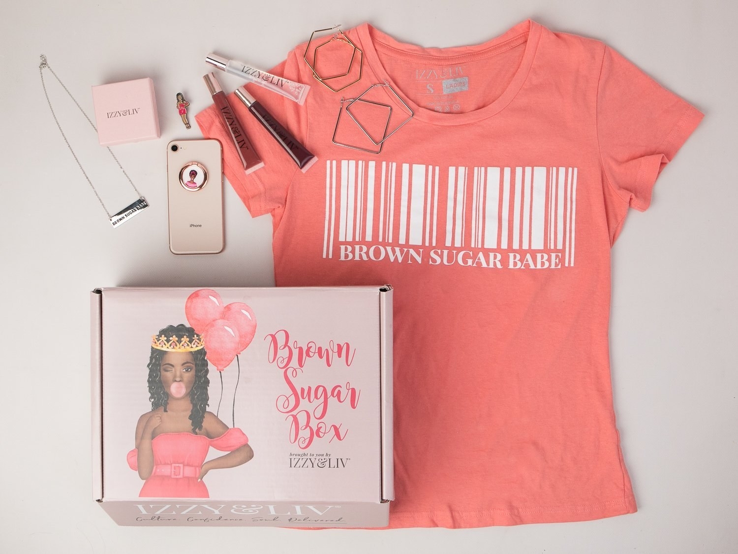the box with a shirt that has a bar code on it and says "Brown Sugar Babe" with some jewelry and makeup