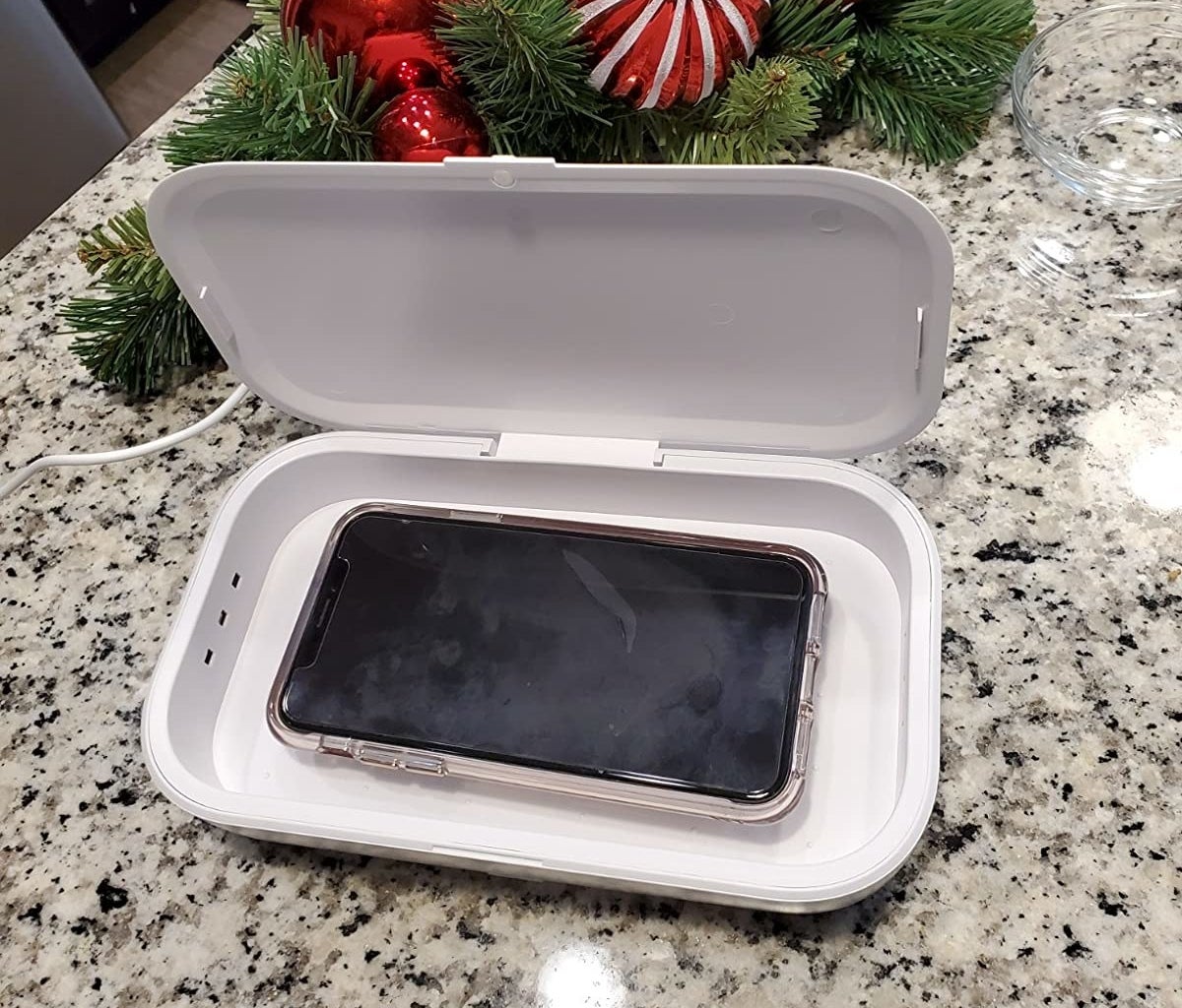 reviewer photo showing their phone in the sanitizing box 