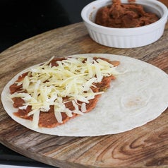 Cheese and refried beans on a tortilla.
