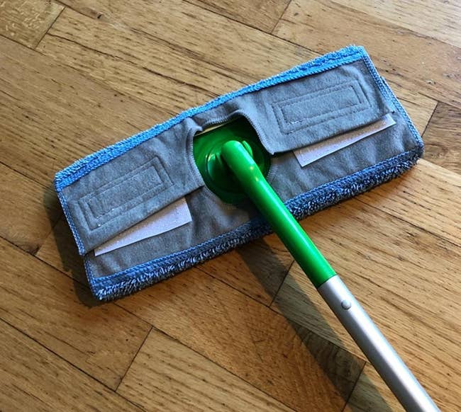 A reviewer photo of the reusable microfiber pad on a standard Swiffer Sweeper