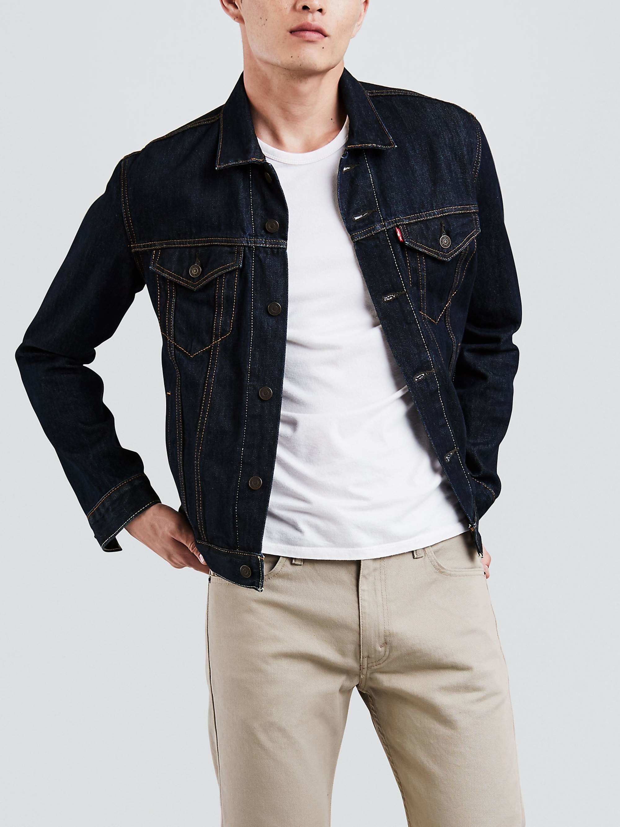 person wearing a dark wash denim jacket with a white t-shirt and khaki pants