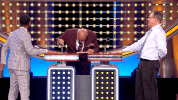 Steve Harvey and two contestants laughing