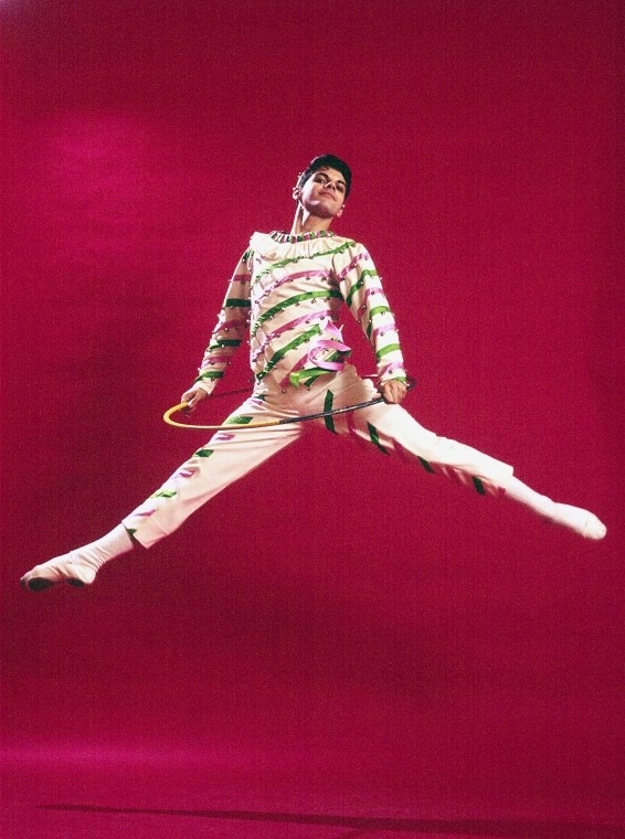 Boy in candy cane outfit leaping in the air