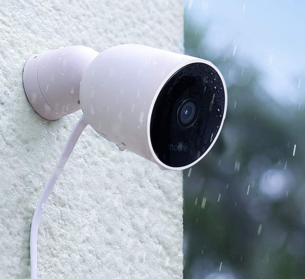A tubular wifi camera attached to the outside of a house in the rain