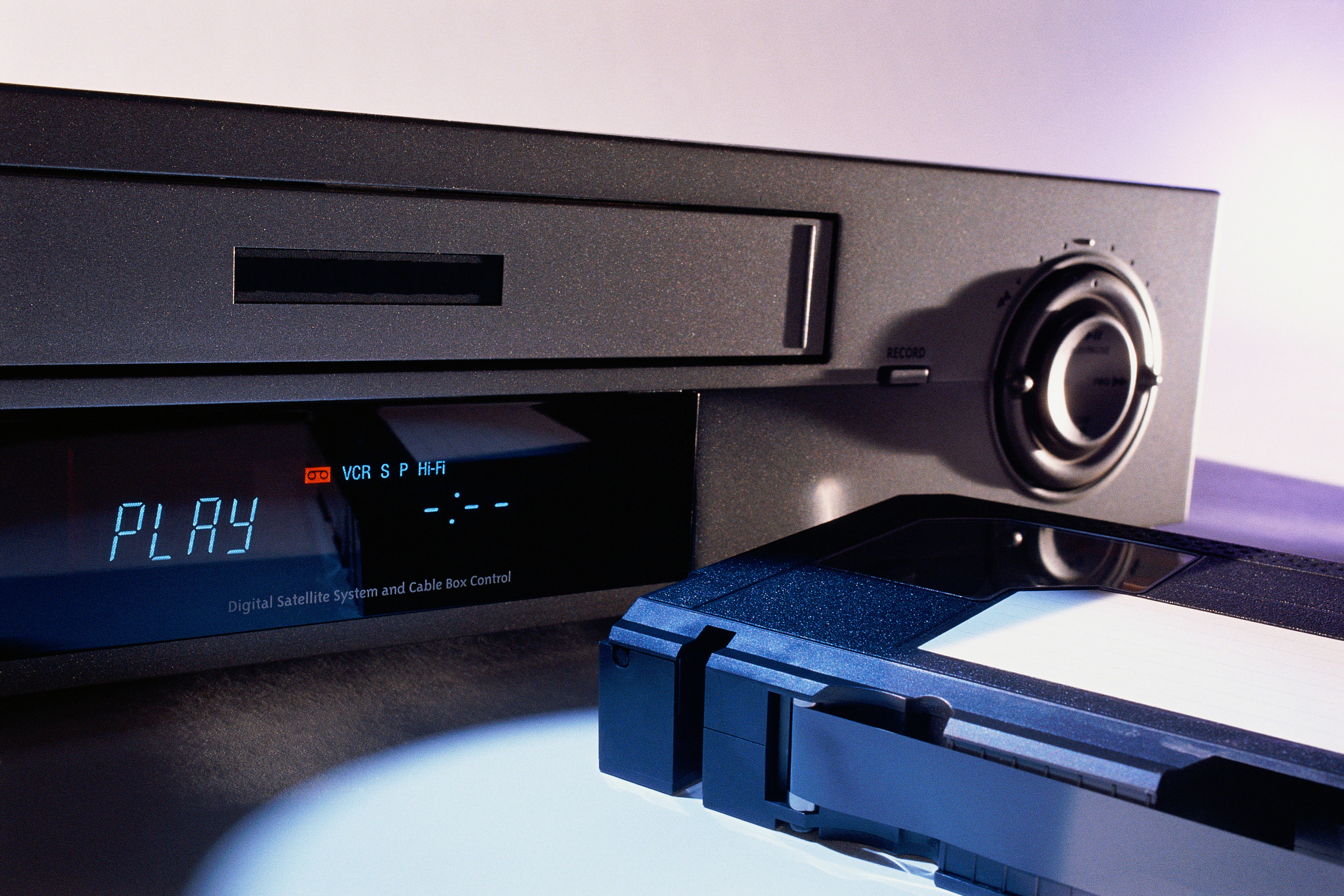 A VCR next to a VHS tape